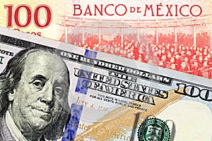 A Mexican one hundred peso bill with an American one hundred dollar bank note