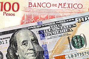 A Mexican one hundred peso bill with an American one hundred dollar bank note