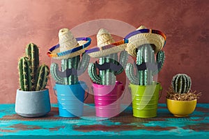 Mexican party concept with cactus and sombrero hat on wooden blue table over wall background. Cinco de Mayo holiday celebration