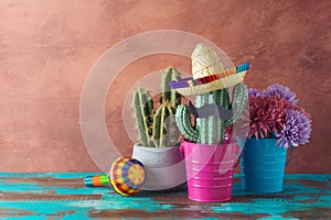 Mexican party concept with cactus and sombrero hat on wooden blue table over wall background. Cinco de Mayo holiday celebration