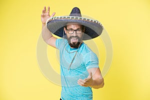 Mexican party concept. Man cheerful happy face in sombrero hat celebrating yellow background. Guy with beard looks