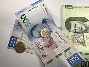 Mexican peso bills spread over white background