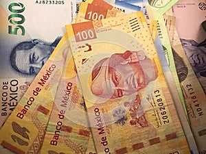 Mexican peso bills spread randomly over a flat surface