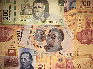 Mexican peso bills spread randomly over a flat surface