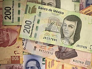 Mexican peso bills spread randomly over a flat surface