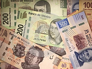 Mexican peso bills spread randomly over a flat surface