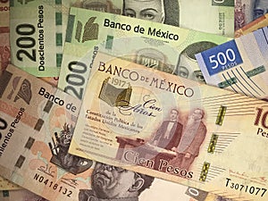 Mexican peso bills spread randomly over a flat surface