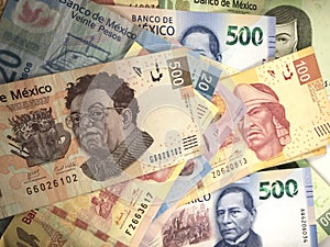 Mexican peso bills spread randomly over a flat surface