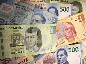 Mexican peso bills spread randomly over a flat surface