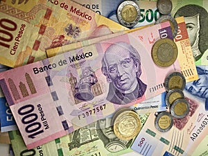 Mexican peso bills spread randomly over a flat surface