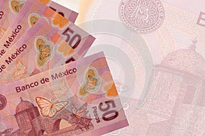 50 mexican pesos bills lies in stack on background of big semi-transparent banknote. Abstract business background photo