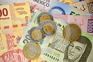 Mexican pesos bills spread randomly over a flat surface