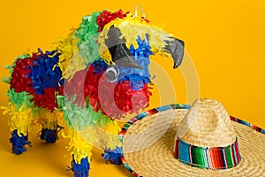 Mexican pinata and sombrero on yellow