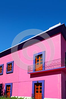 Mexican pink house facade wooden doors