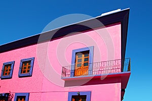 Mexican pink house facade wooden doors