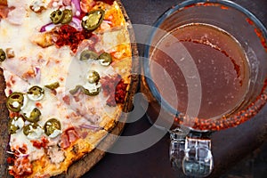 Mexican pizza with a michelada drink with beer and clamato on the side photo