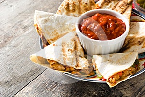 Mexican quesadilla with chicken, cheese and peppers on wood