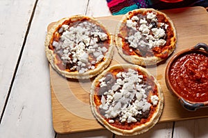 Mexican red sopes with cheese and beans on white background