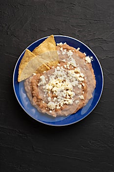 Mexican refried beans with cheese and totopos