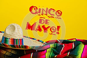 Mexican Serape blanket and sombrero on yellow background with Cinco de Mayo. photo