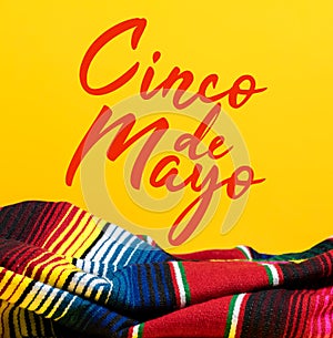 Mexican Serape blanket on yellow background with Cinco de Mayo. photo