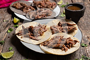 Mexican slow cooked lamb tacos also called barbacoa on wooden background photo