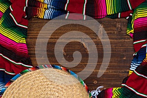 Mexican Sobrero and Serape blanket on wooden background with cop