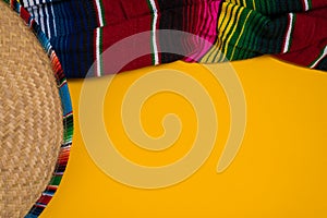 Mexican Sobrero and Serape blanket on yellow background with cop