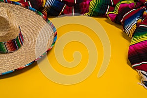 Mexican Sobrero and Serape blanket on yellow background with cop