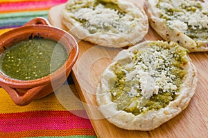 Mexican sopes with grated cheese and green salsa, mexican food spicy in mexico