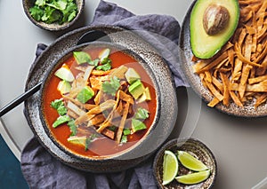 Mexican style table with spicy aztec soup with fried tortilla. Sopa azteca