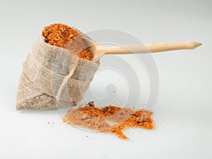 Mexican Taco spice in a jute bag with a stuck wooden spoon on a light background