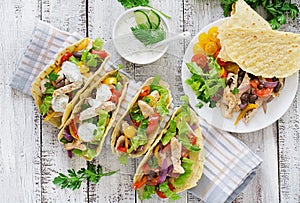 Mexican tacos with chicken, black beans and fresh vegetables and tartar sauce