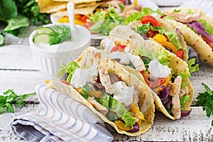 Mexican tacos with chicken, black beans and fresh vegetables and tartar sauce