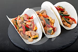 Mexican tacos with pork and vegetables. Al pastor taco on slate tableware.