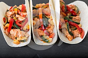 Mexican tacos with pork and vegetables. Al pastor taco on slate tableware.