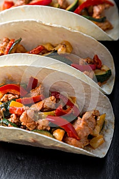 Mexican tacos with pork and vegetables. Al pastor taco on slate tableware. Close up.