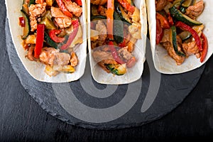 Mexican tacos with pork and vegetables. Al pastor taco on slate tableware. Top view.