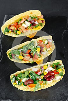 Mexican tacos with vegetables on a dark background on a slate. Reducetarian, flexitarian, pescatarian eating. Top view