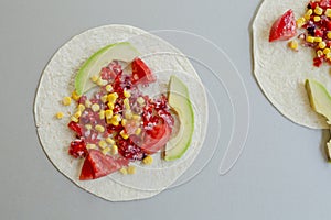 Mexican tacos with vegetarian fillings on light table, cooking process