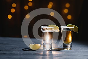 Mexican Tequila with lime and salt on wooden table, selective focus. Copyspace