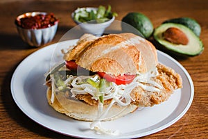 Mexican torta is chicken milanese sandwich with avocado, chili chipotle and oaxaca cheese