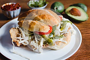 Mexican torta is chicken milanese sandwich with avocado, chili chipotle and oaxaca cheese photo