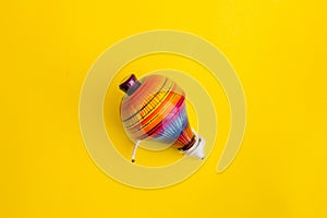 Mexican toys, trompo from Wooden in Mexico on yellow background photo
