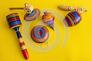 Mexican toys from Wooden, balero, yoyo and trompo in Mexico on a yellow background photo