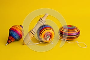 Mexican toys from Wooden, balero, yoyo and trompo in Mexico on a yellow background photo