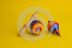 Mexican toys from Wooden, balero, yoyo and trompo in Mexico on a yellow background photo