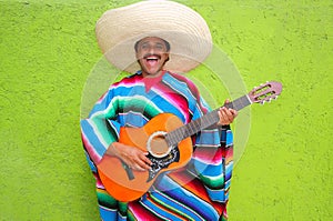 Mexican typical man playing guitar poncho