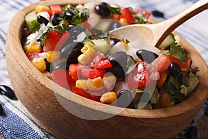 Mexican vegetable salad macro in a wooden plate. horizontal