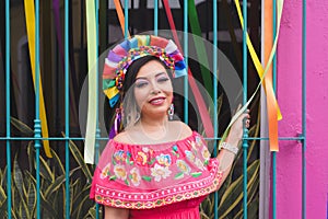 Mexican woman wearing embroidered dress and Lele doll headband.